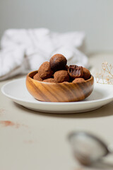 Chocolate truffles covered with cocoa powder. Gray background. Delicious dessert concept.