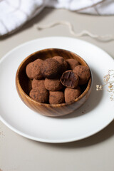 Chocolate truffles covered with cocoa powder. Gray background. Delicious dessert concept.