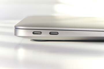 Two USB type-c ports on back side of the closed laptop. Notebook communication ports. High speed...