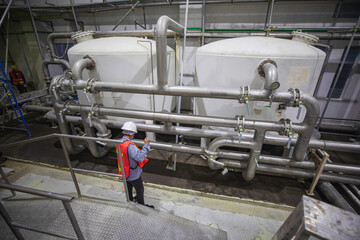 Male work operations process powder cellar at the with vertical stainless steel tanks