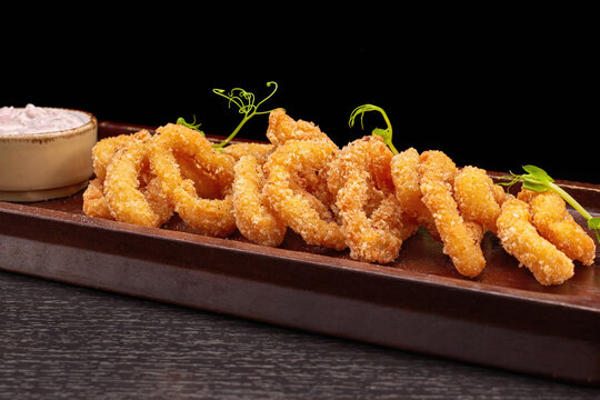 Squid rings in batter on a wooden board