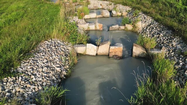 Drone flight over and along curved fish ladder downstream at Inn river in the sunset