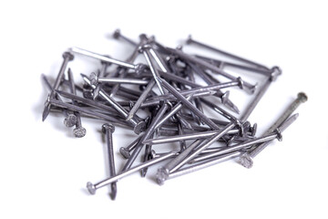 Pile of small grey metal nails isolated on white background. Close-up