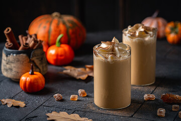 Autumn pumpkin spice latte with whipped cream and cinnamon on dark background