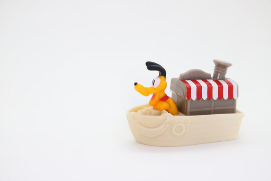 Collectible toy for children on white background isolated with copy space. Pluto the dog sailing on a steamboat at the Disney World parks. 