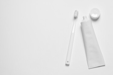 Plastic toothbrush and paste on white background, top view. Space for text
