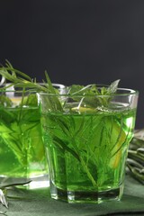 Glasses of refreshing tarragon drink on table, closeup