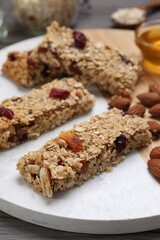 Tasty granola bars on board, closeup view