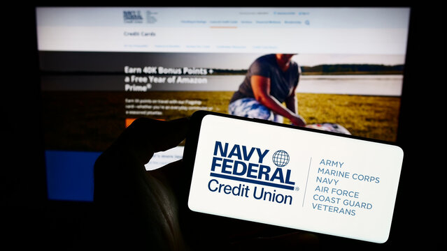 Stuttgart, Germany - 08-18-2023: Person Holding Cellphone With Logo Of Financial Instituation Navy Federal Credit Union On Screen In Front Of Webpage. Focus On Phone Display.