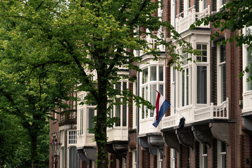 distinctive red houses in Amsterdam, Netherlands, with flag