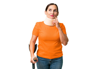 Middle-aged caucasian woman wearing neck brace over isolated background thinking an idea while looking up