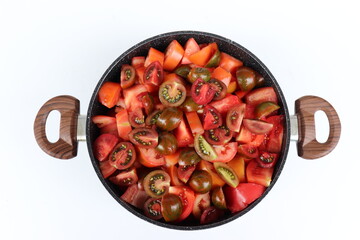 Bunte Tomatenstücke in Topf zum Einkochen.