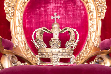 Ancient crown on red velvet. Antique symbol of authority, luxury, monarchy, nobility