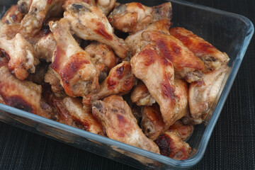 Baked chicken wings in a glass container