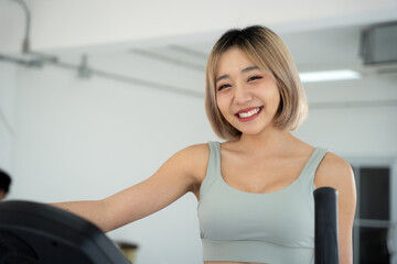 Fototapeta premium Portrait of sport woman exercise at gym. She looking to camera and smile while exercise at gym.