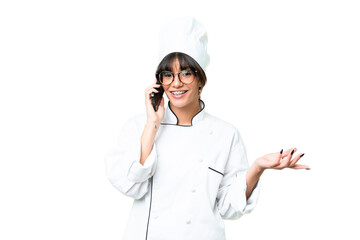 Young caucasian chef  woman over isolated chroma key background keeping a conversation with the mobile phone with someone