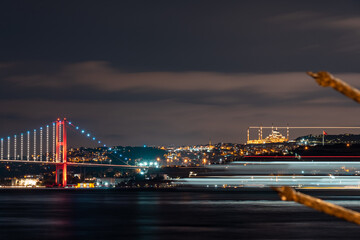 View of Camlica Mosque and Bosphorus Bridge. colored lines formed by the lights of the moving steamers. A beautiful night view of the Bosphorus. Istanbul Türkiye