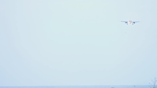 Passenger plane approaching before landing. Aircraft fliea in the blue sky, long shot. Tourism and travel concept, air flight