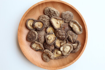 Dried paddy straw mushroom, or straw mushroom, or Volvariella volvacea, on wooden plate. Flat lay or top view