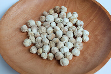 Dried cardamom fruit and seeds on wooden plate