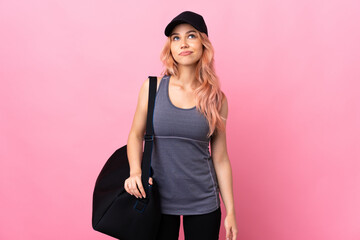 Teenager sport woman with sport bag over isolated background and looking up