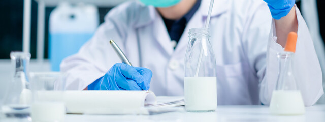 Expert nutritionist hold milk bottle delves quality analysis in laboratory of nutrition, lactose,...