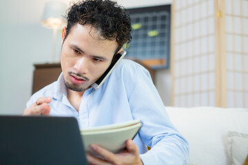 Skilled salesman is explaining agreement to customer with laptop and mobile phone, he use technology and wireless communication to engage in effective consulting and close the deal from home office.