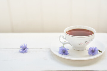 The composition of the drink from chicory, cups and saucers on a wooden table with space for copying. A healthy drink made from chicory. High quality photo