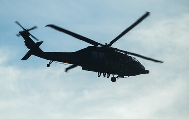 Military helicopter in mission. Silhouette of an army military helicopter and soldiers with their...