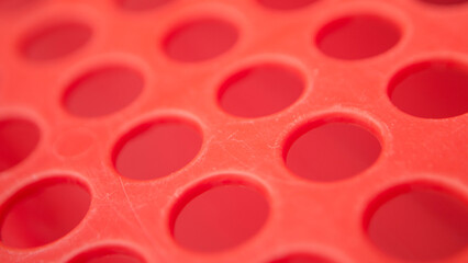 Detalles de agujeros redondos en escurre platos de plastico rojo