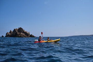 People floating in kayak on sea