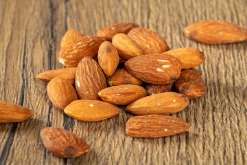 A bunch of almond nuts on a wooden table close-up