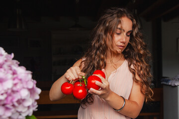 Young woman in front of window with fresh tomatoes