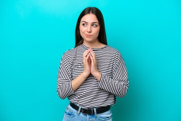 Young caucasian woman isolated on blue background scheming something