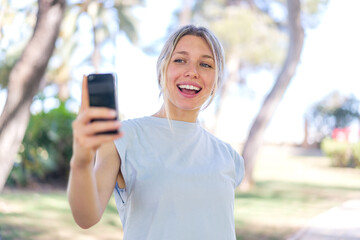 Young blonde woman at outdoors making a selfie