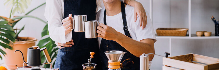 Happy young adult couple making breakfast and drinking coffee together in cozy home kitchen in morning at home. Preparing meal and smiling. Lifestyle, leisure and Love concept.