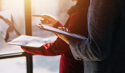 Entrepreneur Asian businessman and businesswoman discussing new business project in tablet in modern Meeting In Modern Office, Asian business casual concept.