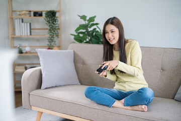 Young Asian woman gamer controller video console playing holding hobby playful Online Video Game...