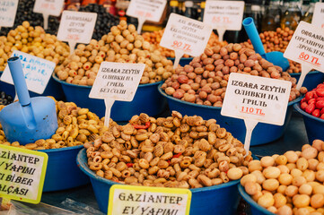 Different olives sale in the traditional farm Turkish market, a counter filled with fresh fruits