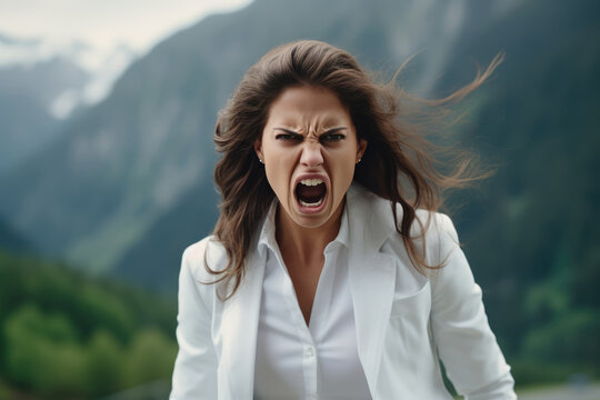 Anger European Woman In White Blazer On Mountain Scenery Background. Сoncept Anger, European Women, White Blazer, Mountain Scenery