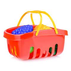 A toy shopping basket isolated on a white background. Plastic grocery basket with fruit, close-up. The concept of shopping. Layout for a supermarket