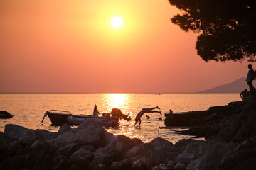 Sunset cliff divers in Baska Voda, Croatian coast