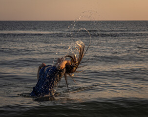 kobieta kąpiąca się w morzu wymachująca swoimi włosami