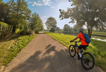 nice woman with electric mountain bike, cycling in moody morning light on the Neckar valley bicycle...