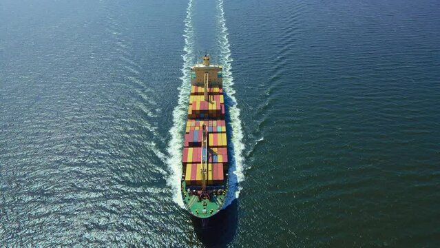 Loaded container ship cruising open ocean sea for logistics import export, aerial shot
