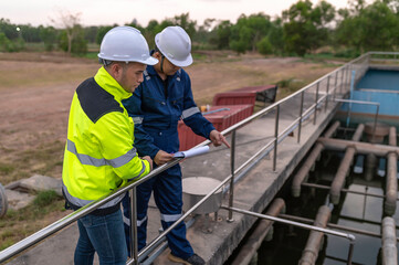 Fototapeta na wymiar Environmental engineers work at wastewater treatment plants,Water supply engineering working at Water recycling plant for reuse,Technicians and engineers discuss work together.