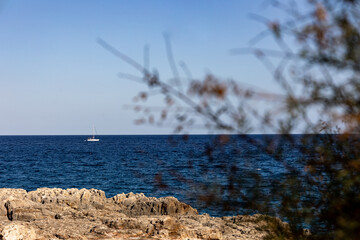 Sailing Ship on the sea in front of a rocky coast
