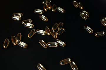 Fish oil capsules on 
black background