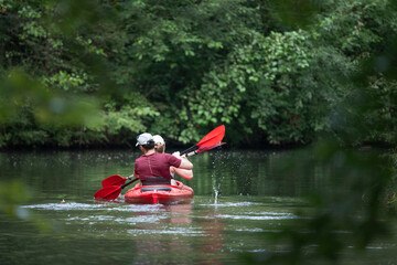 A couple is relaxing in nature while kayaking on a wild river. Active rest and health.