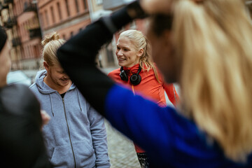 Young group of friends getting ready to go running and jogging in the city together during colder weather in winter or autumn